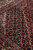 Detail of navy corner spandrel with Herati diamonds and cream vine guard stripe beside red field