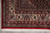 Corner view of ivory main border, multiple guard stripes and neatly tied ivory cotton fringe