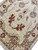 Rust red leaf sprays and pale blue grey rosettes woven across the cream wool field