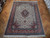 9'10" x 13' Persian Tabriz rug displayed on parquet floor showing ivory field and coral borders