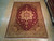 9x12 Persian Heriz rug laid flat on light wood floor showing full geometric medallion layout