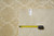 Back tag reading genuine hand woven oriental rug beside a tape measure on ivory pile