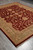 8' x 10'1" burgundy and green Chobi rug shown from the corner on grey flooring