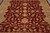 Close angled look at burgundy field covered in palmettes, serrated leaves and scrolling gold vines