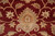 Macro shot showing hand-knotted wool pile and a large peach palmette against wine red ground
