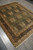 Angled view of the 8x10 Ziegler area rug showing cypress rows and cream fringe ends