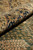 Rolled edge showing pile thickness, navy scrolling border and green field of this new Oriental rug