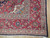 Corner detail showing red palmette border, ivory guard bands and clean white cotton fringe