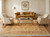 Rug in a panelled room beneath a gold velvet sofa, two cream armchairs and glass table
