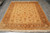 Rug laid flat on grey tile flooring, fringes forward, whole field and border in view