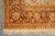 Corner detail with cream border rosettes, gold guard bands and the knotted ivory fringe