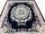 Hand-knotted Oriental rug seen from one end, black field framed by cream corner brackets and blooms