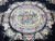 Detail of the central oval medallion ringed by lavender scrollwork and cream rose sprays