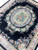 Large 8x10 black Aubusson rug corner view highlighting lustrous bamboo silk sheen and floral garlands