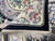 8'2 x 9'10 Aubusson rug folded back to show the hand-knotted woven back and fringe