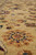 Low angle showing dense wool pile, hand-knotted rosettes and soft luster of the gold ground