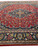 9' x 10'9" Mashad rug at an angle, navy medallion surrounded by scrolling floral vines