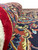 Rolled edge close-up of thick wool pile against navy border with palmettes and vines