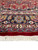 9 by 11 wool Mashad rug end showing fringe, red skirt and floral border stripes