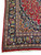Border corner of red Mashad rug with layered guard stripes and blue leaf palmettes