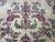 Detail of raspberry pink and blue flower bouquets scattered across the creamy ivory wool field