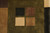 Close-up of olive green block framing four small squares in black, mauve, cream and camel wool