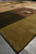 Perspective view along the olive edge panel of this large square contemporary area rug