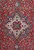 Close-up of ivory and navy star medallion with rosette center on 10x13 red Tabriz rug