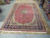 11x17 room size Persian wool rug photographed from the side in natural warehouse light