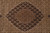 Close-up of the central medallion showing brown, ivory and rust knotting on beige ground