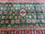8x12 green Kazak rug half view showing medallion rows, ivory guard stripes and red borders