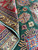 Rug turned back to show tight hand knotted foundation, wool pile depth and wrapped selvage