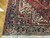 Corner detail of indigo border with rosettes, ivory guard stripes and hand-knotted wool pile