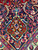 Navy corner spandrel with red cartouche motif, saffron vines and teal florals shown in detail