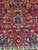 Burgundy field detail with arabesque vines, serrated leaves, gold rosettes and blue pendant motifs