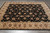 7'10" x 9'8" hand-knotted Tabriz design rug photographed at an angle on grey plank flooring
