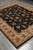 Perspective showroom view of the black Sino Tabriz rug spread across grey tile flooring
