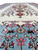 Close-up of seafoam green border with pink rosettes and cream blossoms on hand-knotted Persian wool