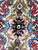 Macro detail of the navy medallion core, gold ground and sky blue palmettes in wool pile