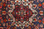 Ivory and crimson star medallion detail with blue rosettes and sharp tribal drawing in wool