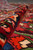 Rolled edge revealing thick springy wool pile, saturated colors and the flexible handle of the weave