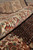 Rolled edge revealing border paisleys, silk sheen and hand-knotted wool construction up close