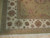 Corner detail of ivory border with olive palmettes, guard stripes and clean cotton fringe ends