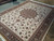 Angled view showing 8 point medallion and teal burgundy palmettes across the cream field