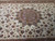 Salmon rust medallion surrounded by gold, navy and aqua flowerheads on cream ground
