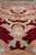 Low angle showing deep wool pile and carved relief around a pastel palmette on burgundy