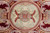 Sage green round rosette at the rug center framed by cream acanthus and ruby beads