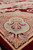 Raised carved outlines catch the light along the corner shield medallion of this wool rug
