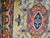 Close view of coral medallion, ivory spandrel and multi-color floral sprays in fine wool