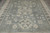 Overhead detail of pomegranate filled roundels, cross flowers and stylized blossoms across the blue gray field
